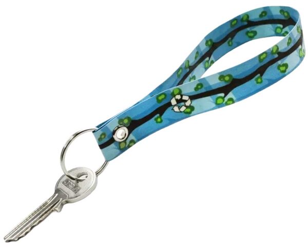 Portachiavi blu in carta impermeabile con disegno di rami e foglie verdi, dotato di anello metallico e chiave. Un accessorio ecologico offerto da AMGS Group.