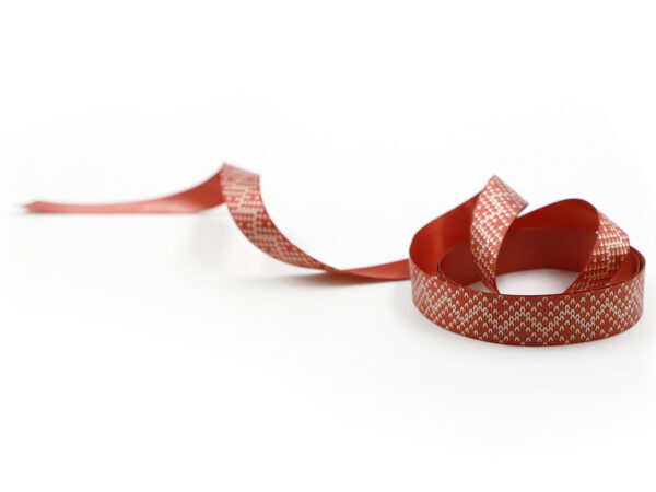 Elegante nastro rosso con piccolo motivo geometrico bianco. Nastro bifacciale, ideale per decorazioni natalizie B2B. Produttore AMGS Group.